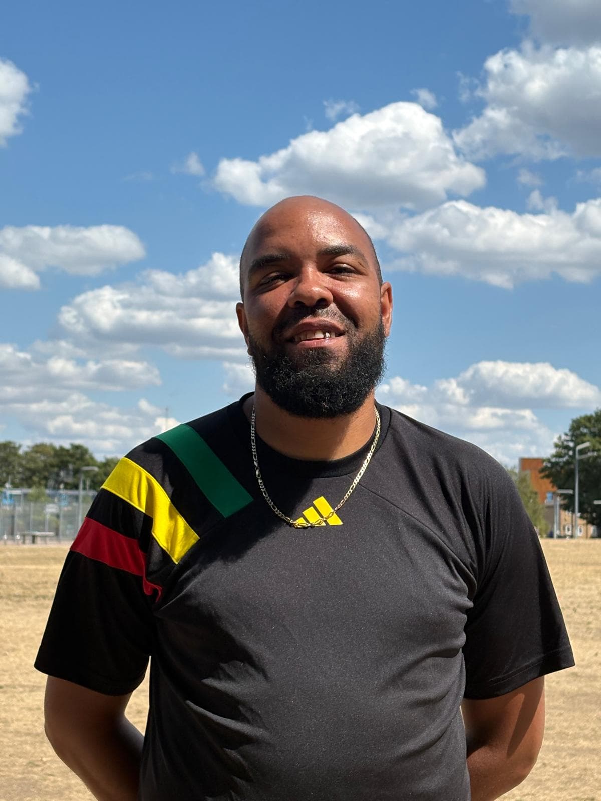Mentor coach standing with arms crossed on the training field